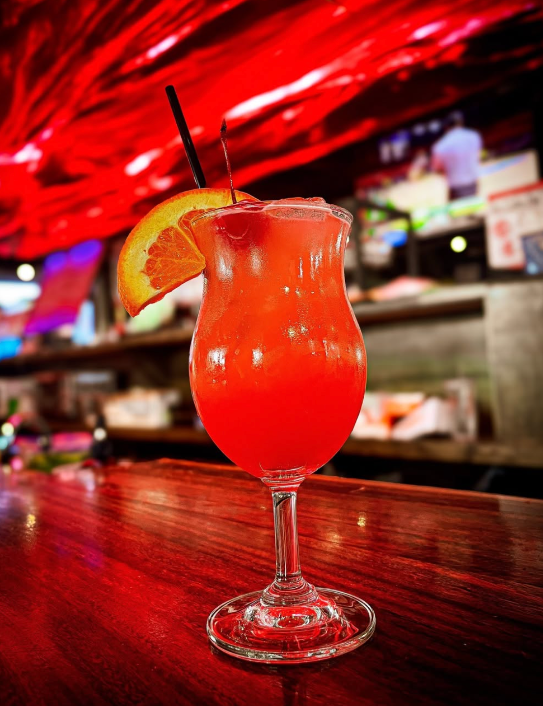 A red cocktail with orange garnish at the Volcano bar
